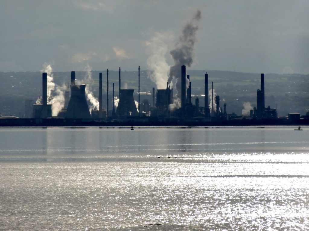 photo of grangemouth industrial site across water with plumes of pollution rising from chimneys 