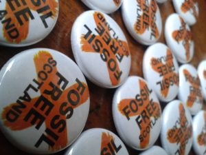 Close up image of Fossil Free Scotland badges
