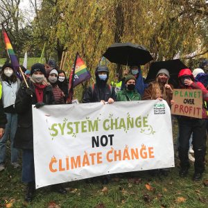 a group of people holding a banner reading system change not climate change