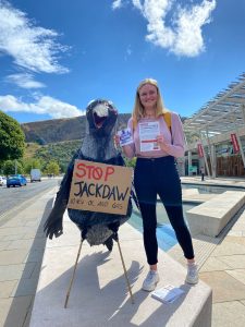 Woman outside Scottish Parliament with a large papier mache Jackdaw