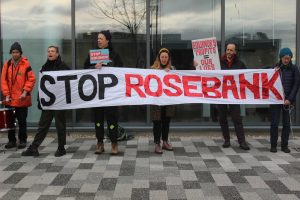 group of protestors standing with large Stop Rosebank banner