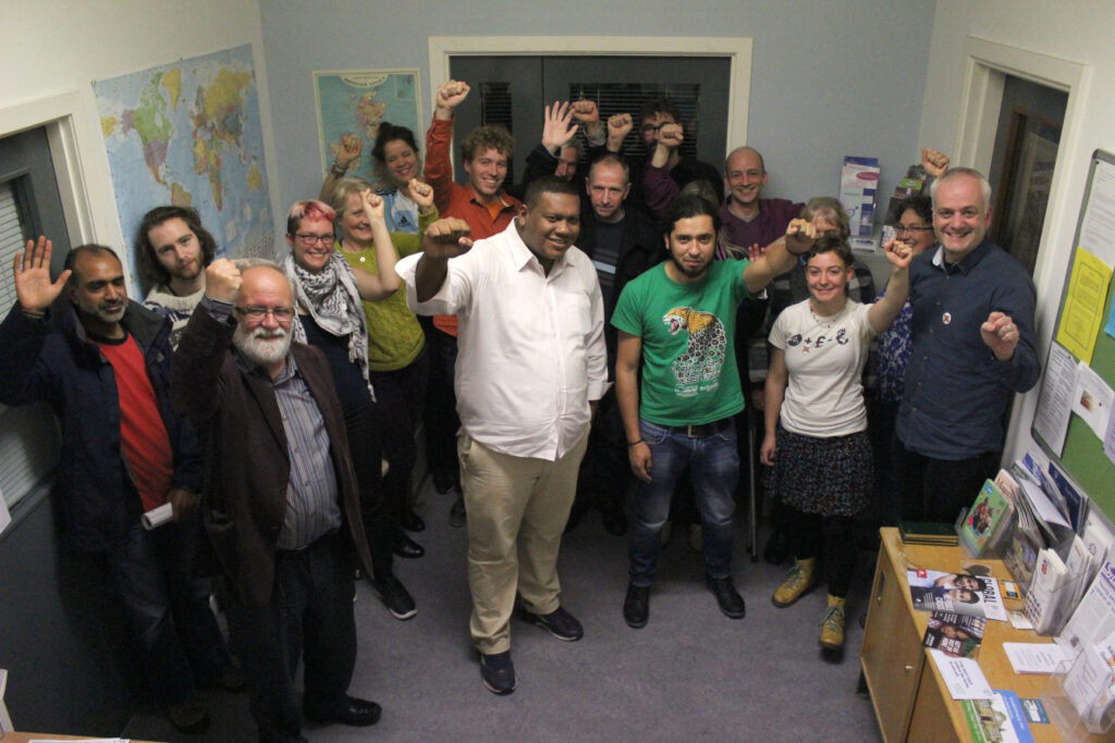 A group of people raise fists in a university room