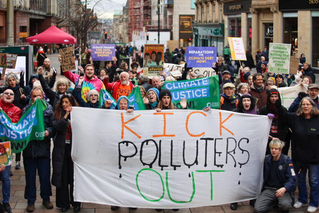 crowd of people with a large banner saying kick polluters out