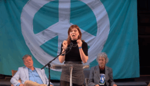 woman in front of large CND banner