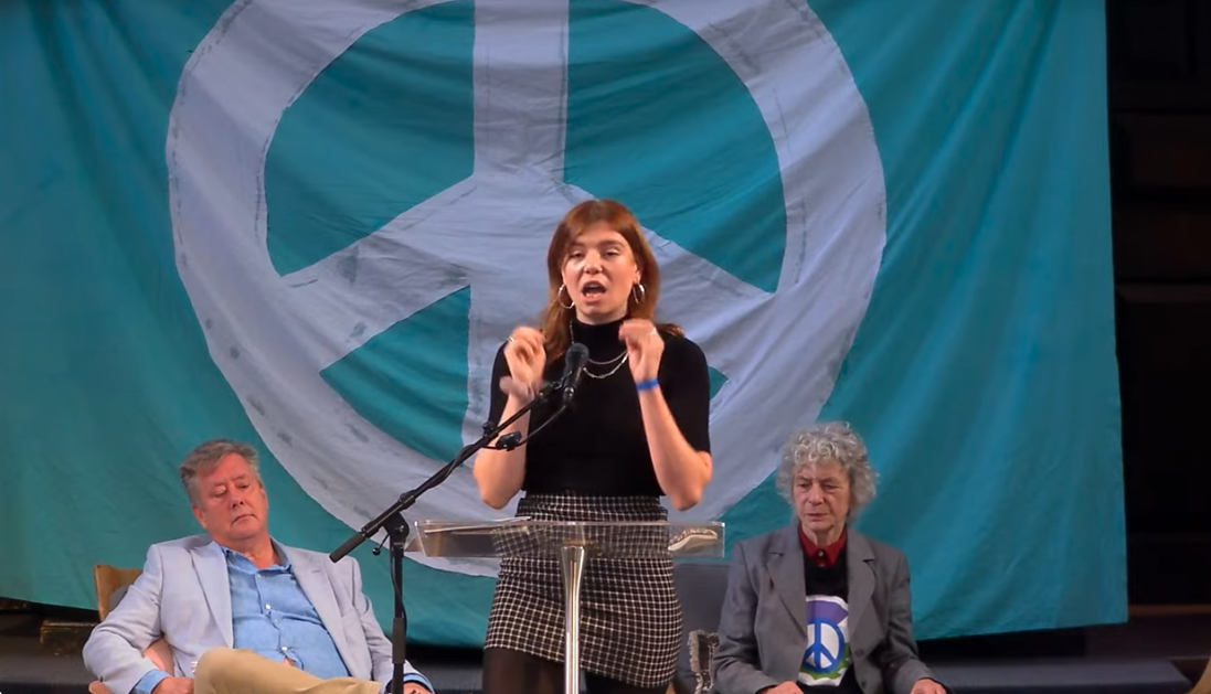 woman in front of large CND banner