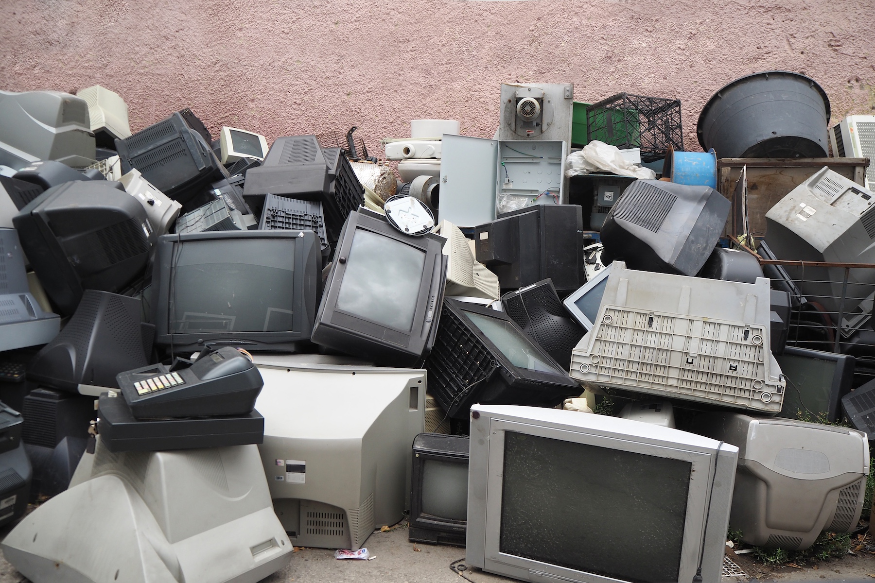 pile of broken monitors and TVs