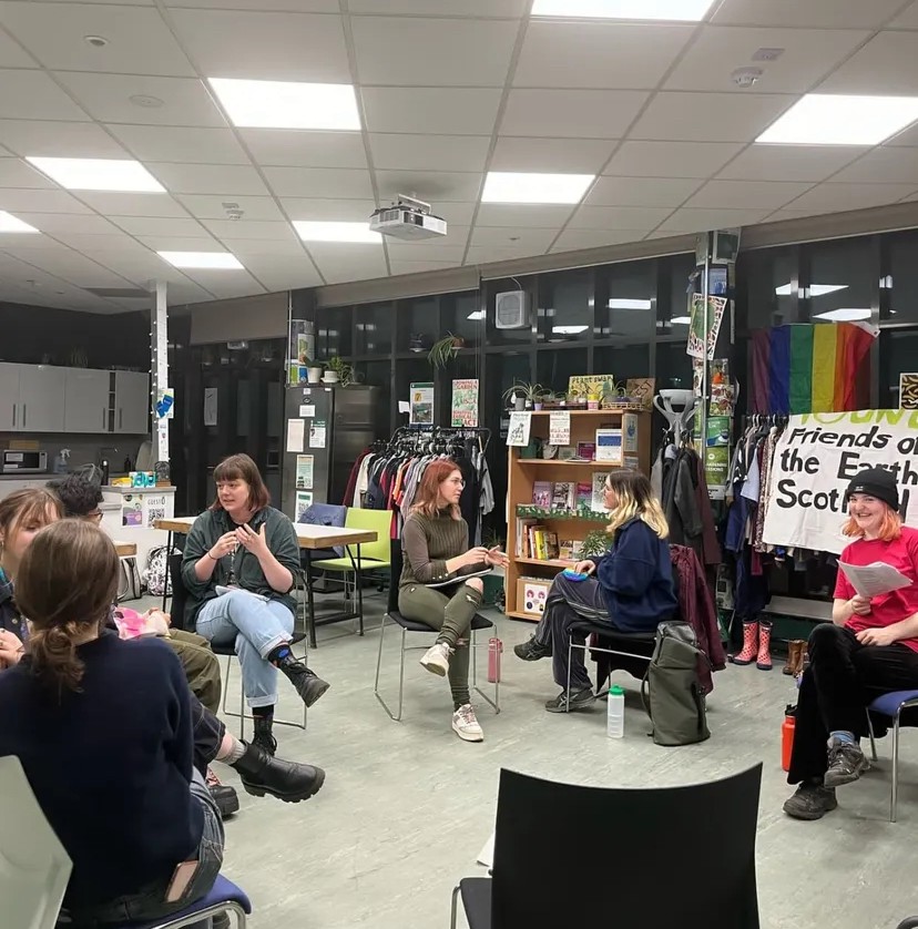 people sitting a circle talking to each other