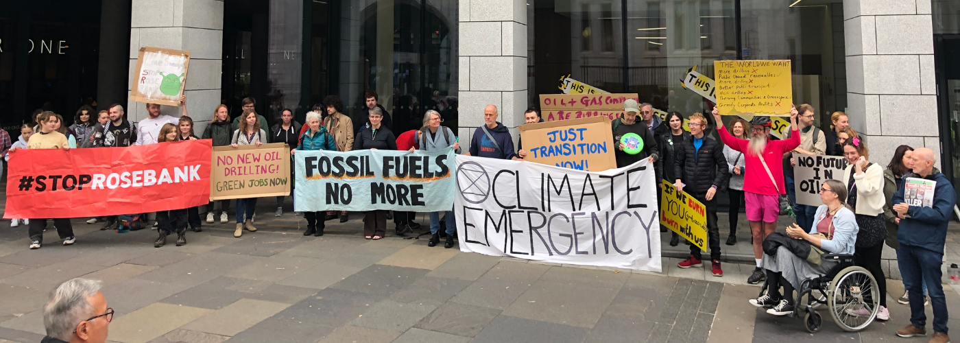 large crowd of people gathered in aberdeen with banners and signs to protest Rosebank oil field