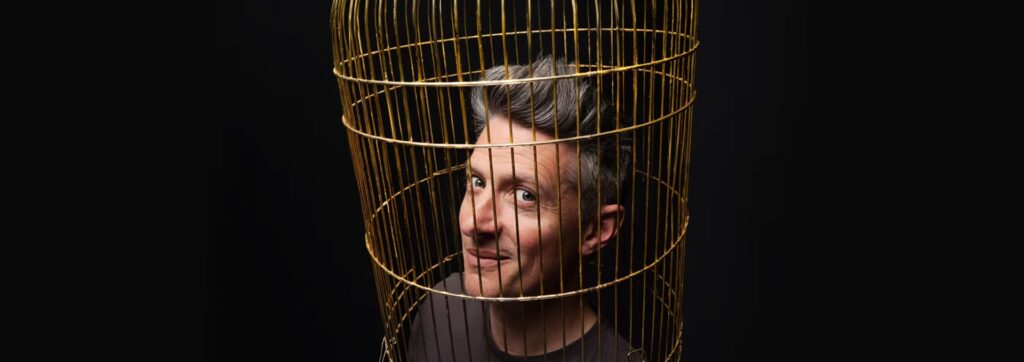 stu goldsmith head in a bird cage