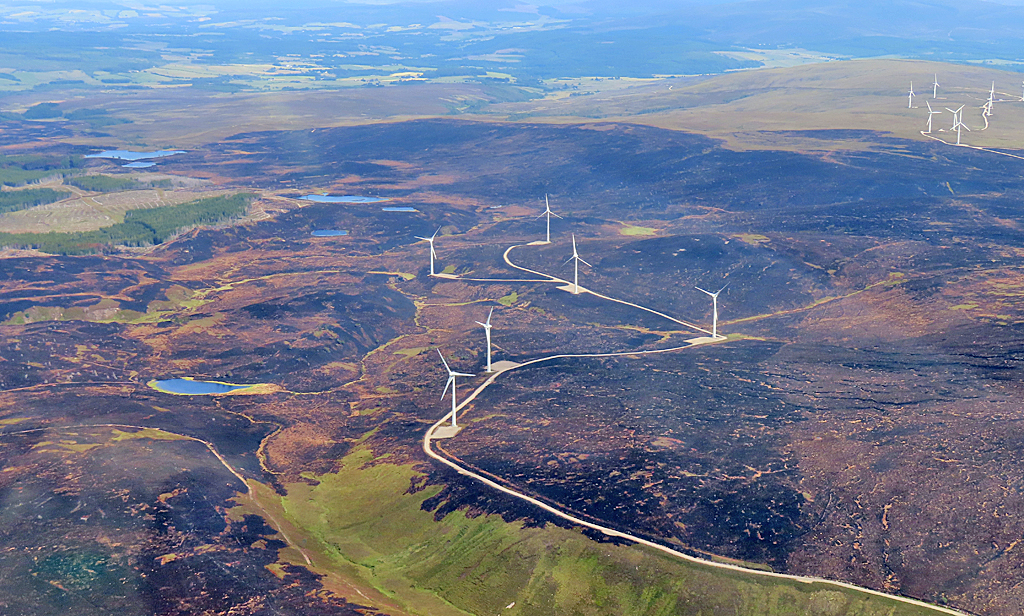 vast area of burned landscape around five wind turbines