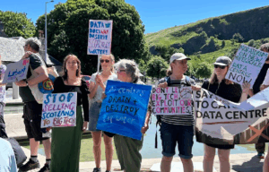 photo of 6 data centre protestors with signs outside the Scottish Parliament