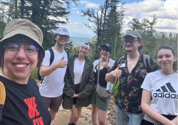six young people in a selfie with a mountain backdrop